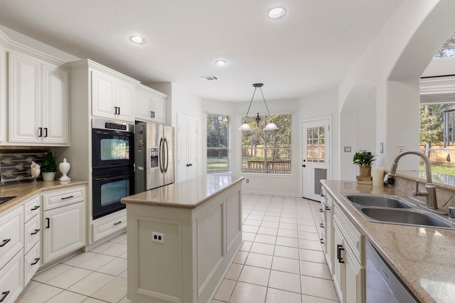 kitchen with white cabinetry, sink, pendant lighting, a chandelier, and appliances with stainless steel finishes