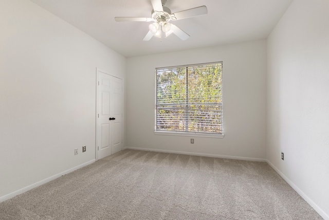 spare room with ceiling fan, carpet floors, and a wealth of natural light