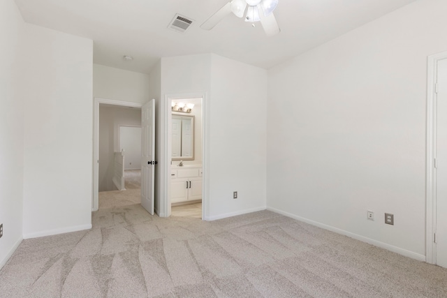 unfurnished bedroom featuring ensuite bath, ceiling fan, and light colored carpet