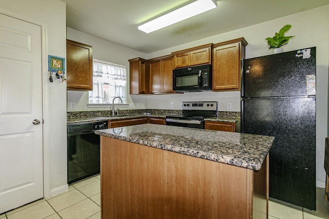 kitchen with black appliances, a center island, light tile patterned floors, and dark stone counters