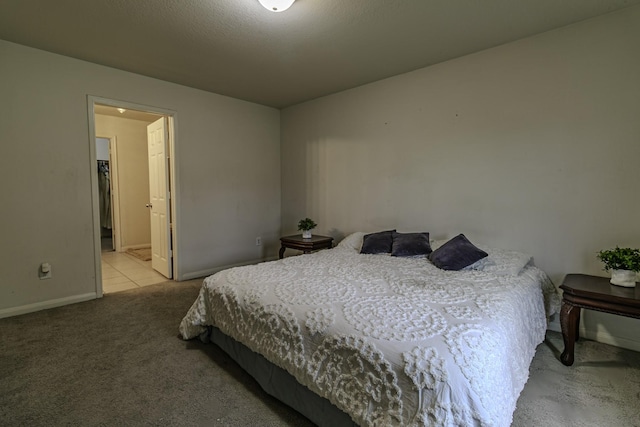 bedroom featuring light colored carpet and ensuite bath