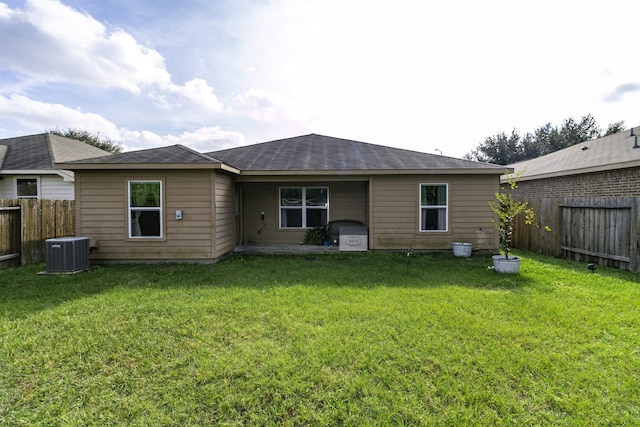 rear view of property with a yard and central AC unit