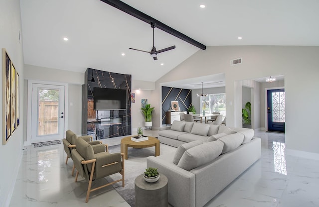 living room featuring vaulted ceiling with beams, a healthy amount of sunlight, and ceiling fan with notable chandelier