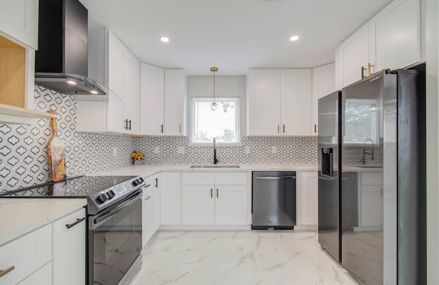 kitchen with white cabinets, sink, wall chimney exhaust hood, and appliances with stainless steel finishes