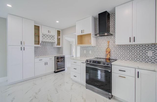 kitchen with wall chimney exhaust hood, wine cooler, stainless steel range with electric stovetop, decorative backsplash, and white cabinets