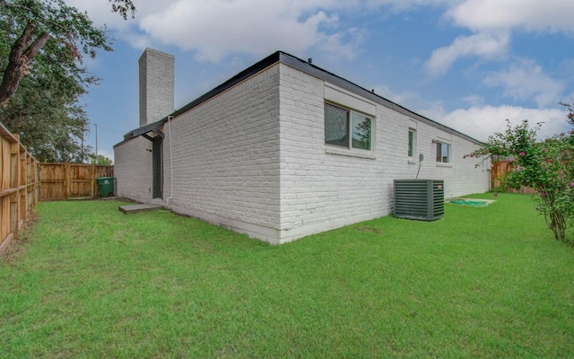 view of home's exterior featuring central AC and a yard