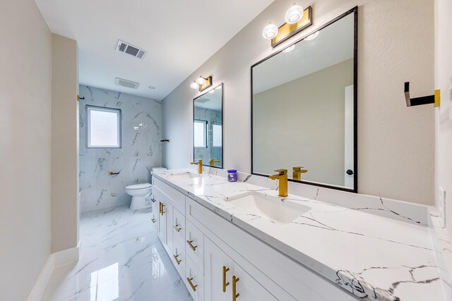 bathroom featuring a tile shower, vanity, and toilet