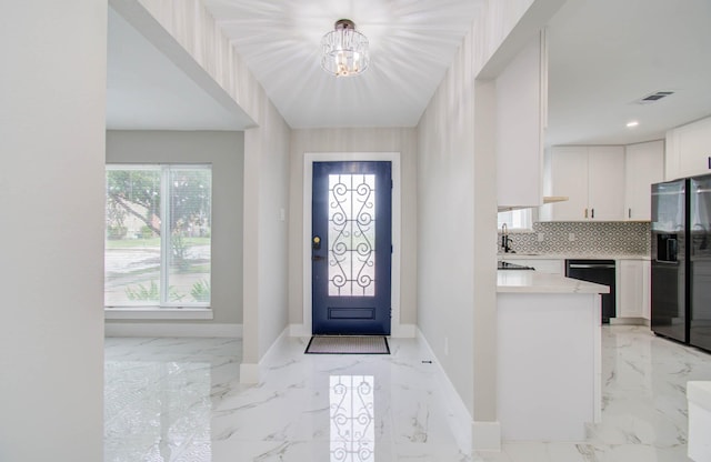 entrance foyer with sink and a notable chandelier