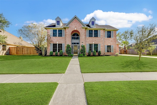 colonial-style house featuring a front lawn