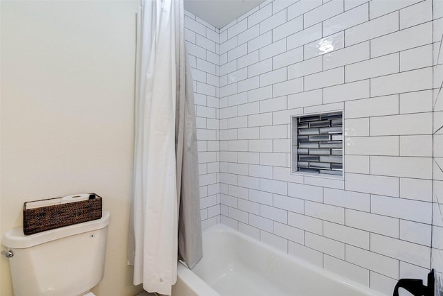 bathroom featuring shower / tub combo and toilet