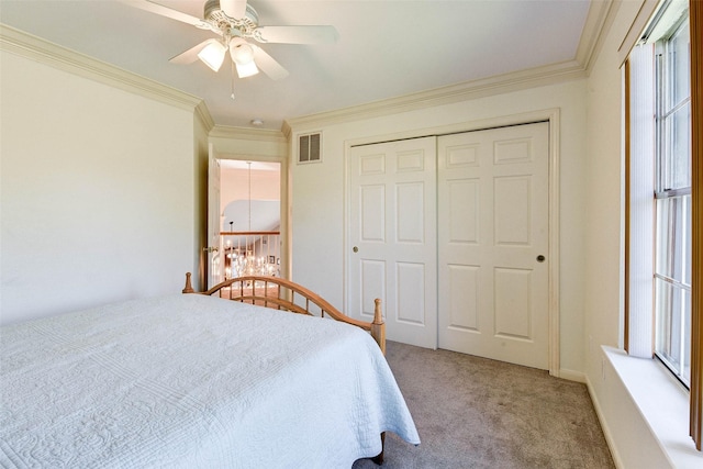 carpeted bedroom with ceiling fan, ornamental molding, and a closet