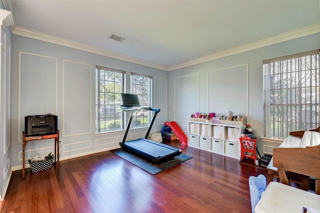 exercise room with dark hardwood / wood-style floors and ornamental molding