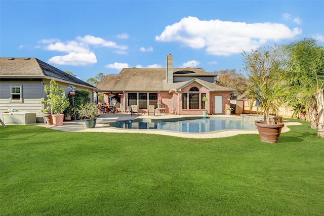 view of pool with a patio and a lawn