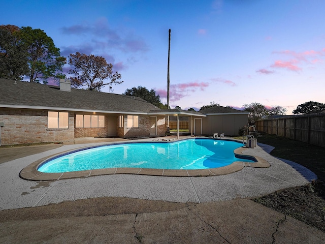 pool at dusk with a patio