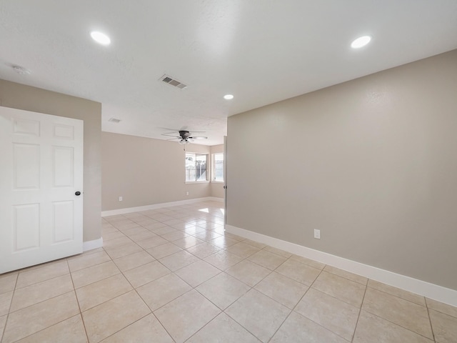 tiled spare room featuring ceiling fan