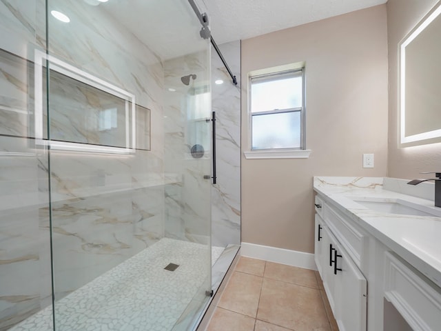 bathroom featuring tile patterned flooring, vanity, a shower with shower door, and a textured ceiling