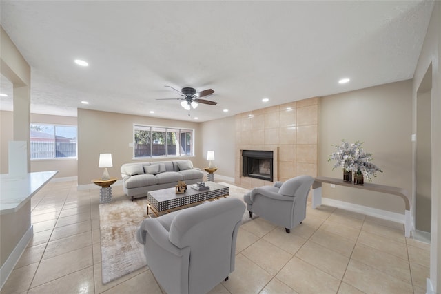 tiled living room with ceiling fan and a fireplace