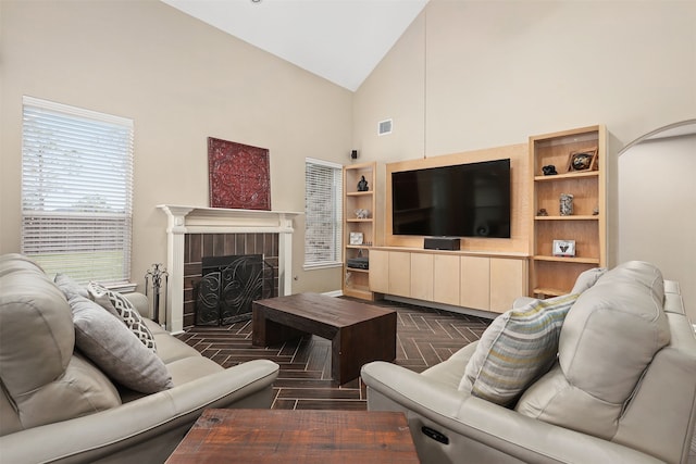 living room with dark parquet flooring, a fireplace, and high vaulted ceiling