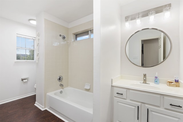 full bathroom featuring hardwood / wood-style floors, vanity, toilet, and tiled shower / bath