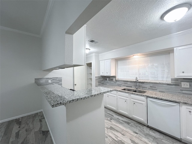 kitchen with kitchen peninsula, stainless steel dishwasher, crown molding, sink, and white cabinets