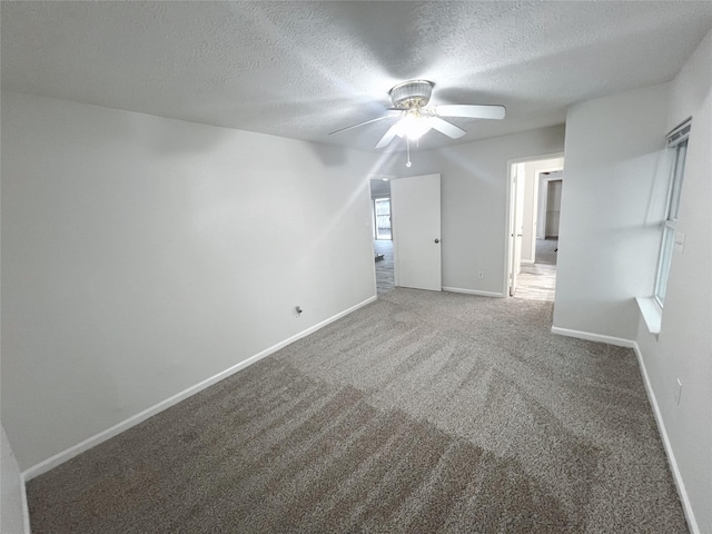 carpeted empty room featuring ceiling fan and a textured ceiling