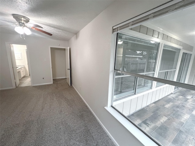 unfurnished bedroom featuring ceiling fan, carpet floors, and a textured ceiling