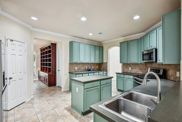 kitchen with a kitchen island, sink, ornamental molding, green cabinets, and stainless steel appliances