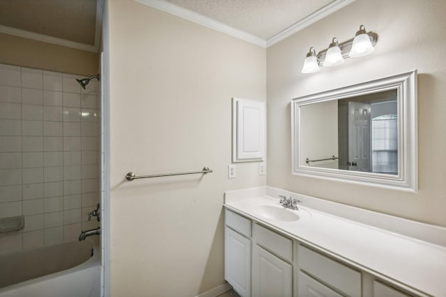 bathroom with tiled shower / bath combo, ornamental molding, vanity, and a textured ceiling