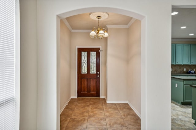 tiled foyer with a notable chandelier and crown molding