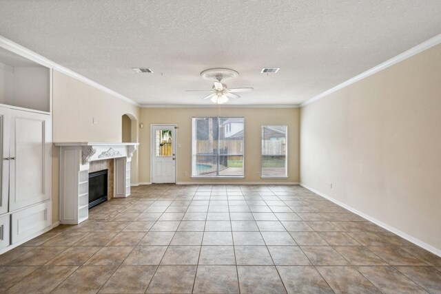 unfurnished living room with a fireplace, ornamental molding, ceiling fan, and light tile patterned flooring