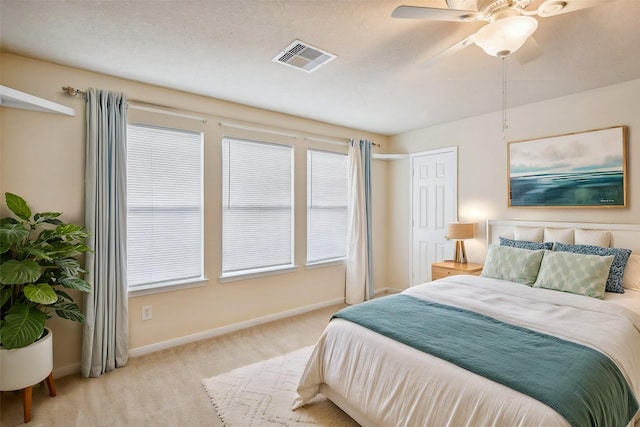 carpeted bedroom featuring a textured ceiling and ceiling fan