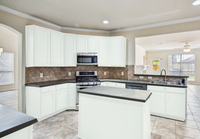 kitchen featuring a kitchen island, white cabinetry, appliances with stainless steel finishes, and sink