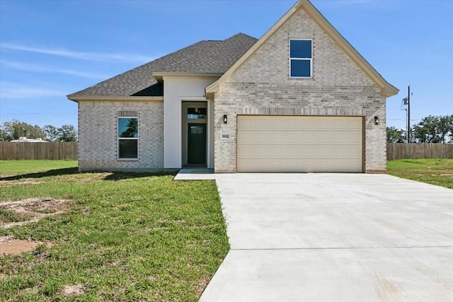 view of front of property featuring a garage and a front lawn