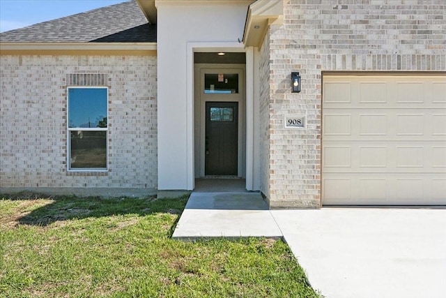 doorway to property with a lawn and a garage