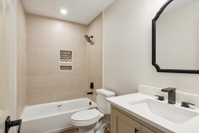 full bathroom with vanity, tiled shower / bath combo, and toilet