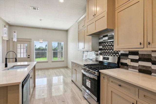 kitchen with sink, stainless steel appliances, pendant lighting, decorative backsplash, and ornamental molding