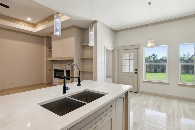 kitchen with hanging light fixtures, crown molding, and sink