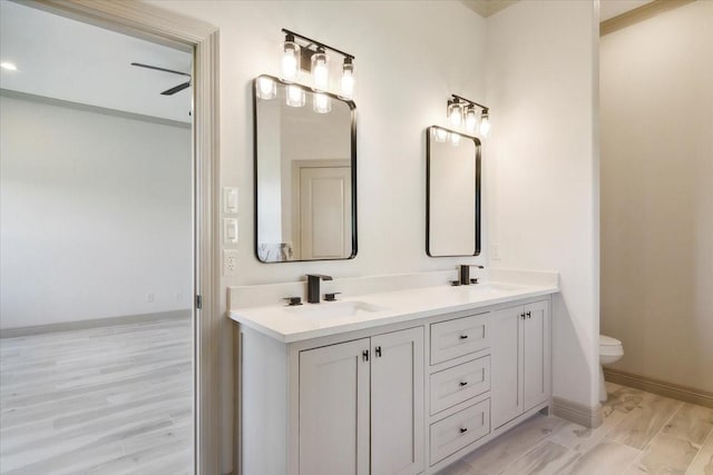 bathroom with ceiling fan, vanity, wood-type flooring, and toilet