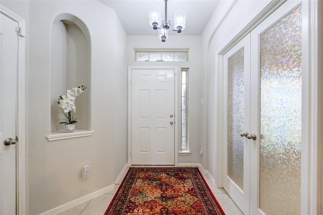 tiled foyer entrance with a chandelier