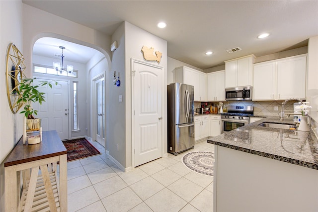 kitchen with white cabinets, light tile patterned flooring, sink, and appliances with stainless steel finishes