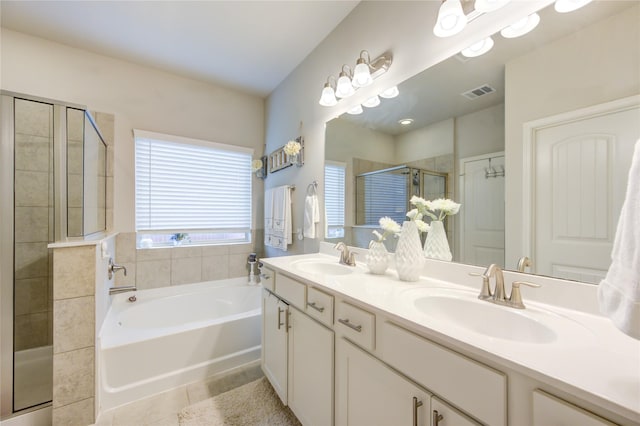 bathroom with vanity, tile patterned flooring, and plus walk in shower