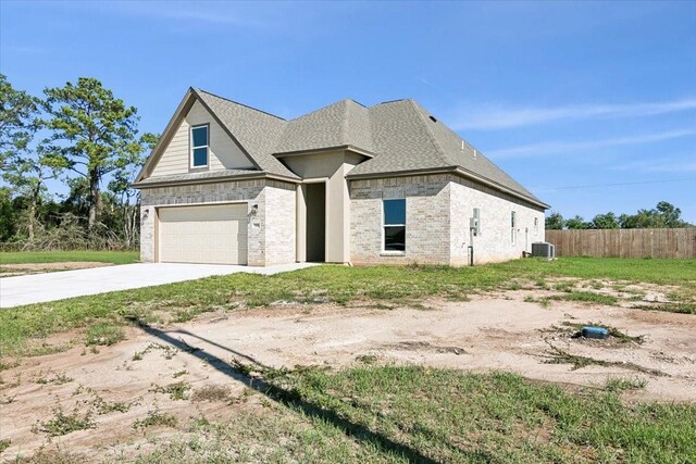 view of front of house featuring central AC unit and a garage