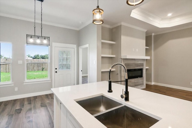 kitchen featuring dark hardwood / wood-style flooring, sink, white cabinets, and decorative light fixtures