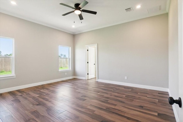 empty room with dark hardwood / wood-style flooring, crown molding, and a healthy amount of sunlight