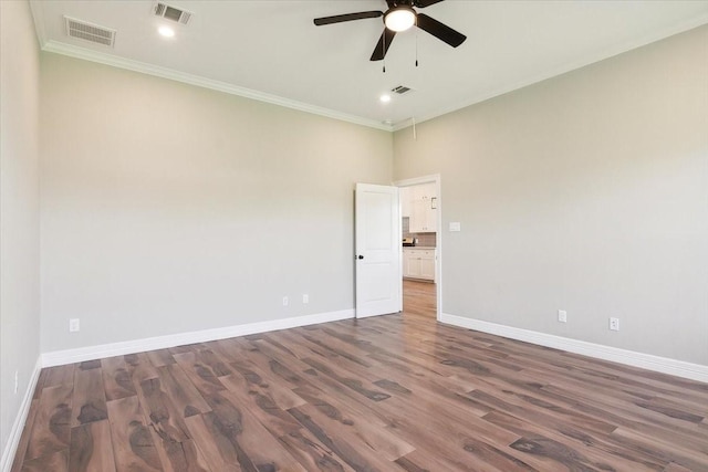 spare room featuring ceiling fan, dark hardwood / wood-style flooring, and crown molding