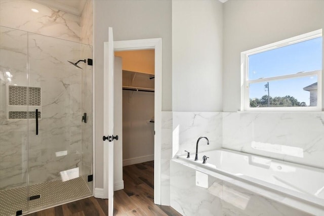 bathroom with hardwood / wood-style flooring and separate shower and tub