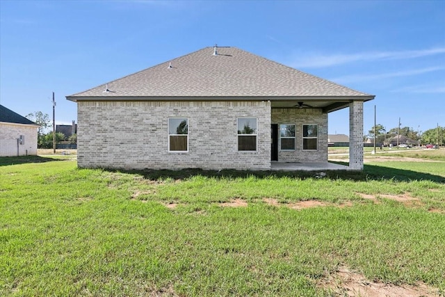 back of house with ceiling fan, a patio area, and a lawn