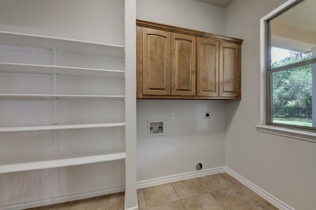 laundry area featuring cabinets, hookup for a washing machine, light tile patterned floors, and electric dryer hookup