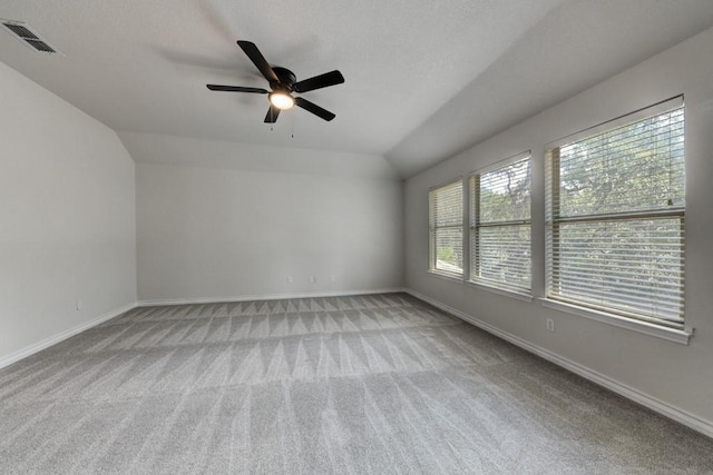 unfurnished room with ceiling fan, light colored carpet, and vaulted ceiling