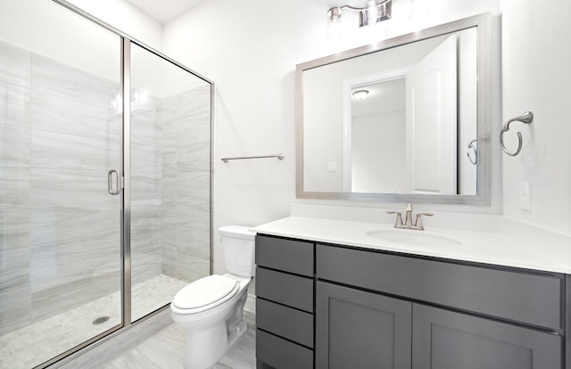 bathroom featuring vanity, toilet, and a shower with shower door